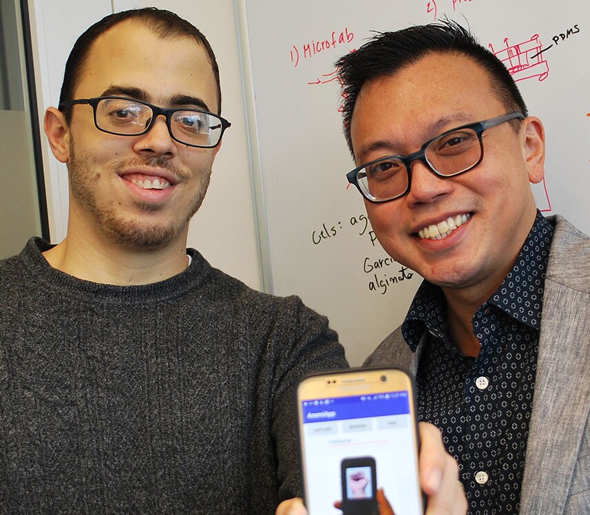 pediatric doctors proudly displaying new anemia app on smartphone
